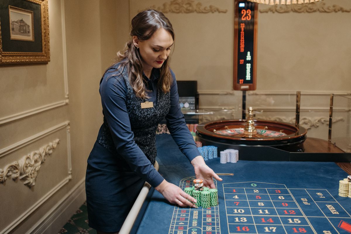Meja roulette dengan dealer dan chip